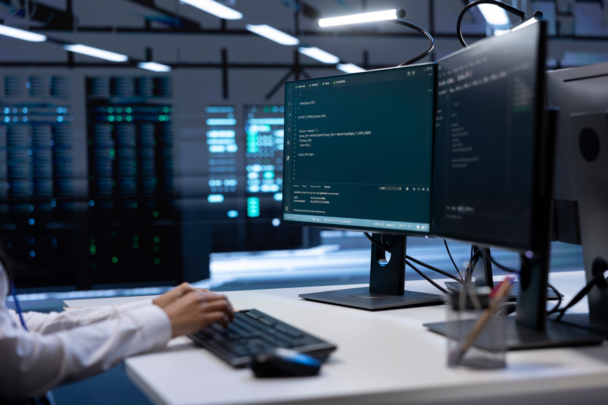 IT expert inputting data on PC in server farm after finishing maintenance