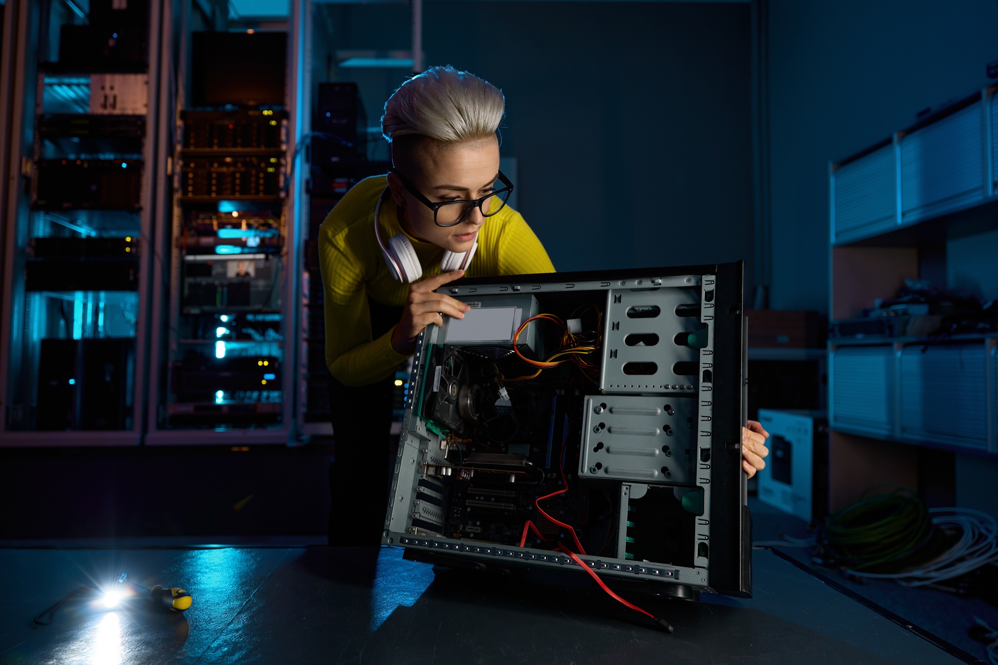Young woman IT technician repairing computer hardware unit